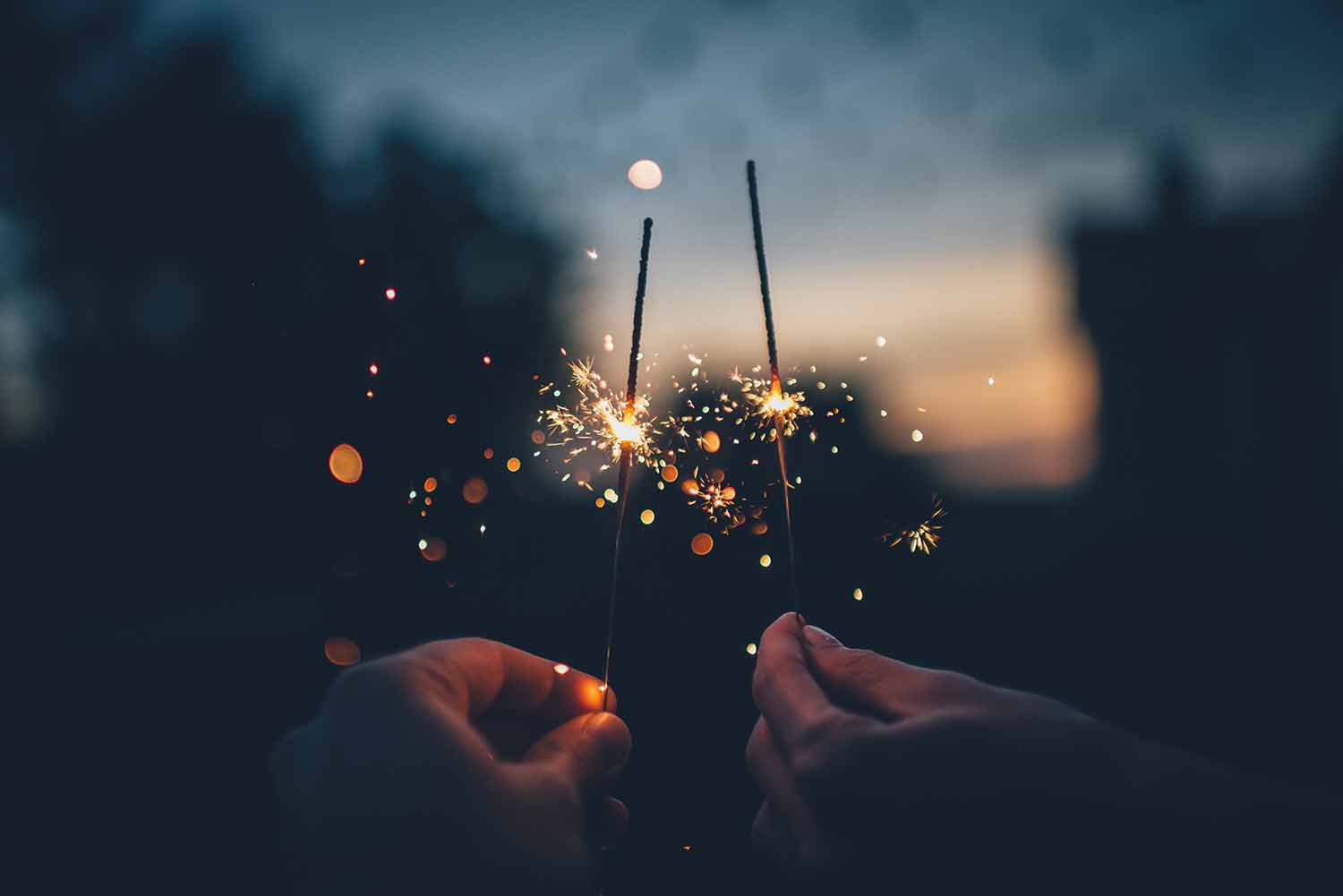 a pair of hands holding sparklers